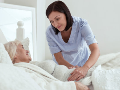 Stomach discomfort. Pleasant happy touching stomach while elder woman resting in bed